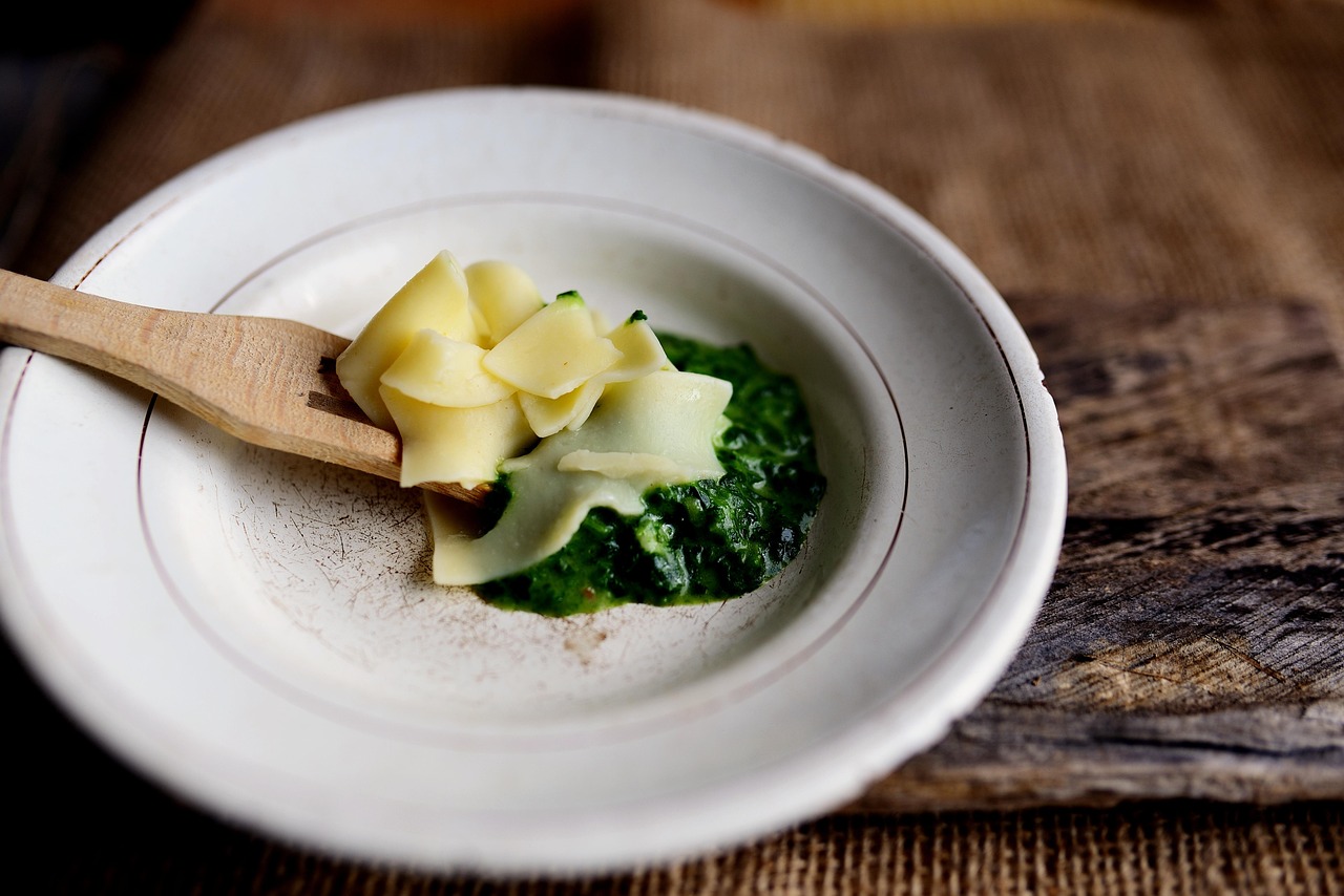 Immagine di un piatto di ragù con vino rosso in evidenza e ingredienti freschi sullo sfondo.