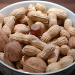 Una ciotola di noci con un cucchiaio, accanto a un taccuino con consigli della nonna.