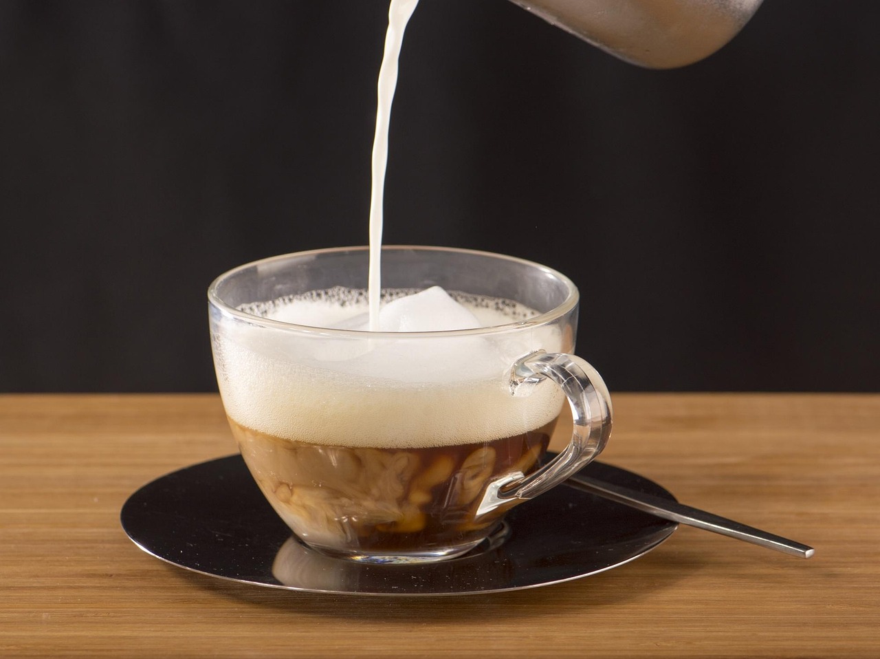 Tazza di caffè con latte freddo, evidenziando la cremosità e il contrasto di colori.