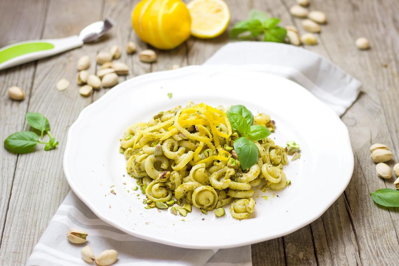 Pesto di pistacchio cremoso fatto in casa, servito in un barattolo di vetro con un cucchiaio.