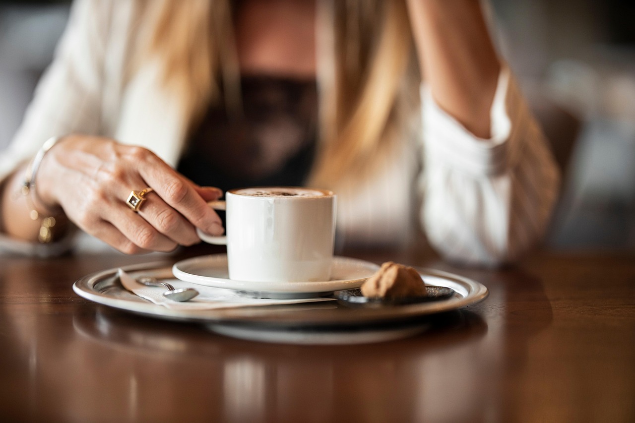 Caffè servito dopo pranzo, con tazza e piattino su tavolo, simbolo di abitudine alimentare.