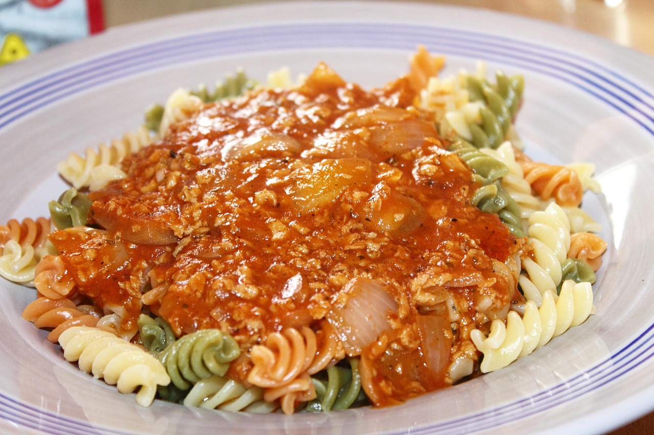 Pasta al ragù di ceci servita in un piatto, con decorazioni di erbe fresche.