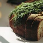 Immagine di una tavola imbandita con piatti vari, senza pane, per una cena salutare.