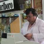 Immagine di un tabaccaio che mostra un Gratta e Vinci vincente con soddisfazione.