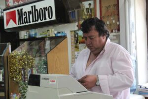 Immagine di un tabaccaio che mostra un Gratta e Vinci vincente con soddisfazione.