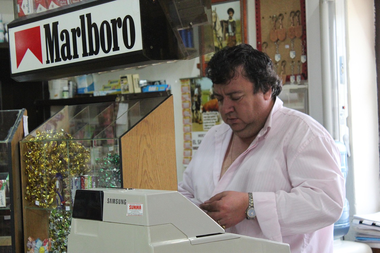 Immagine di un tabaccaio che mostra un Gratta e Vinci vincente con soddisfazione.