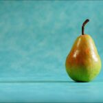 Pere fresche su un tavolo, simbolo dei benefici per la glicemia nel consumo quotidiano.