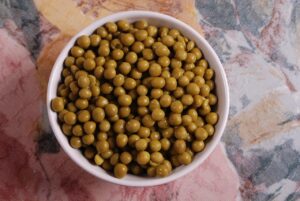 Piselli surgelati in una pentola, pronti per essere cotti secondo il trucco dell'articolo.