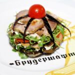 Melanzane a funghetto cotte in padella, con pomodoro e basilico, pronte da servire.