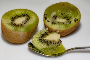 Kiwi con buccia, ricco di fibre e nutrienti, su un tavolo di legno.