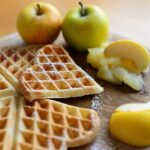 Frittelle di mele dorate su un piatto, pronte per essere gustate.