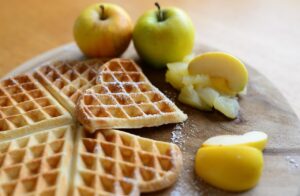 Frittelle di mele dorate su un piatto, pronte per essere gustate.