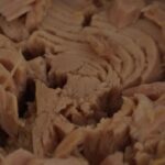 Immagine di una lattina di tonno con etichetta, evidenziando i rischi per salute e memoria.