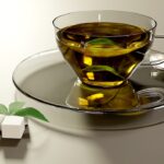 Tazza di tè verde fumante con foglie fresche e limone, simbolo di un'efficace bevanda dimagrante.