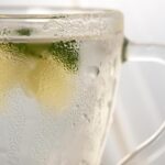 Tazza di acqua calda con limone su un tavolo, simbolo di una routine salutare per la perdita di peso.