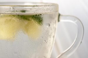 Tazza di acqua calda con limone su un tavolo, simbolo di una routine salutare per la perdita di peso.